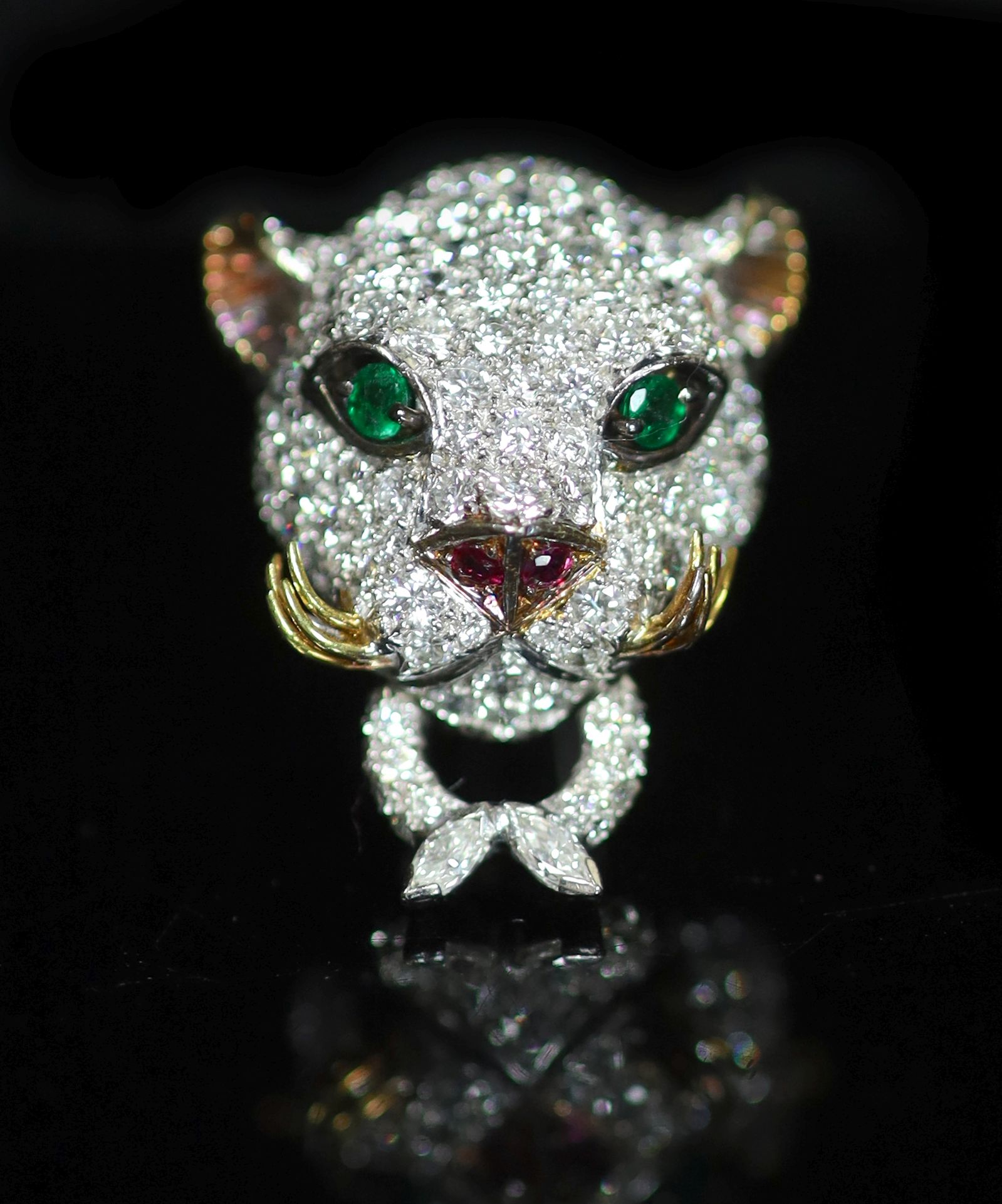An 18K white gold and diamond leopard's head clip brooch, with emerald eyes, ruby nose and gold whiskers,